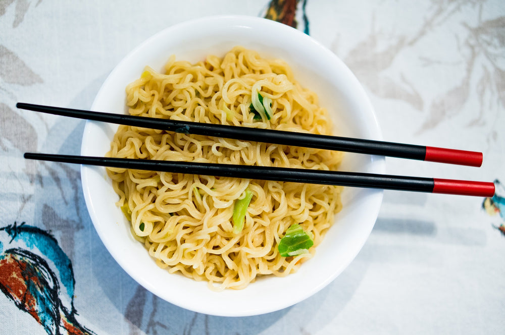 Bowl of noodles with chopsticks on top